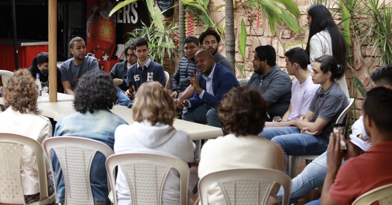 Luis Gilberto Murillo dialogando con un grupo de jóvenes al aire libre