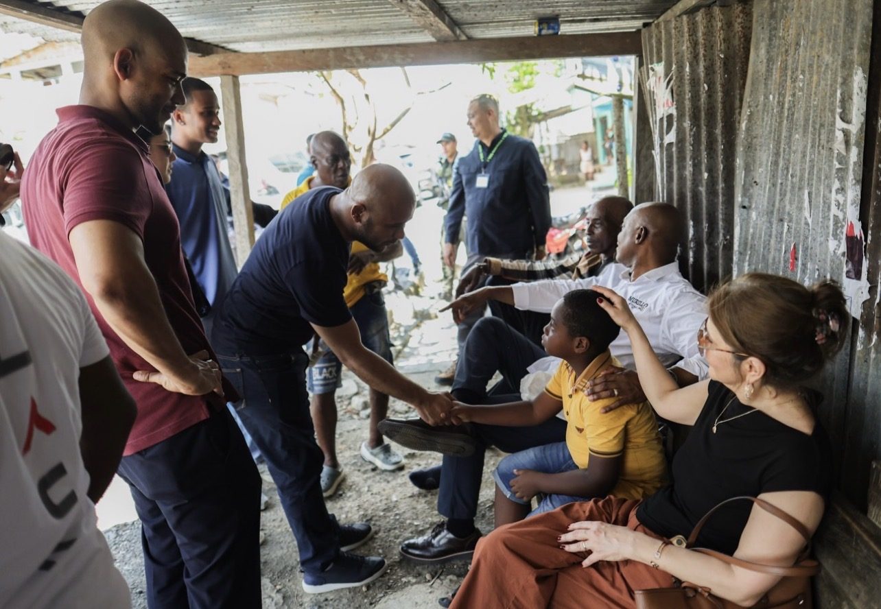 Luis Gilberto Murillo saludando a una familia en una comunidad