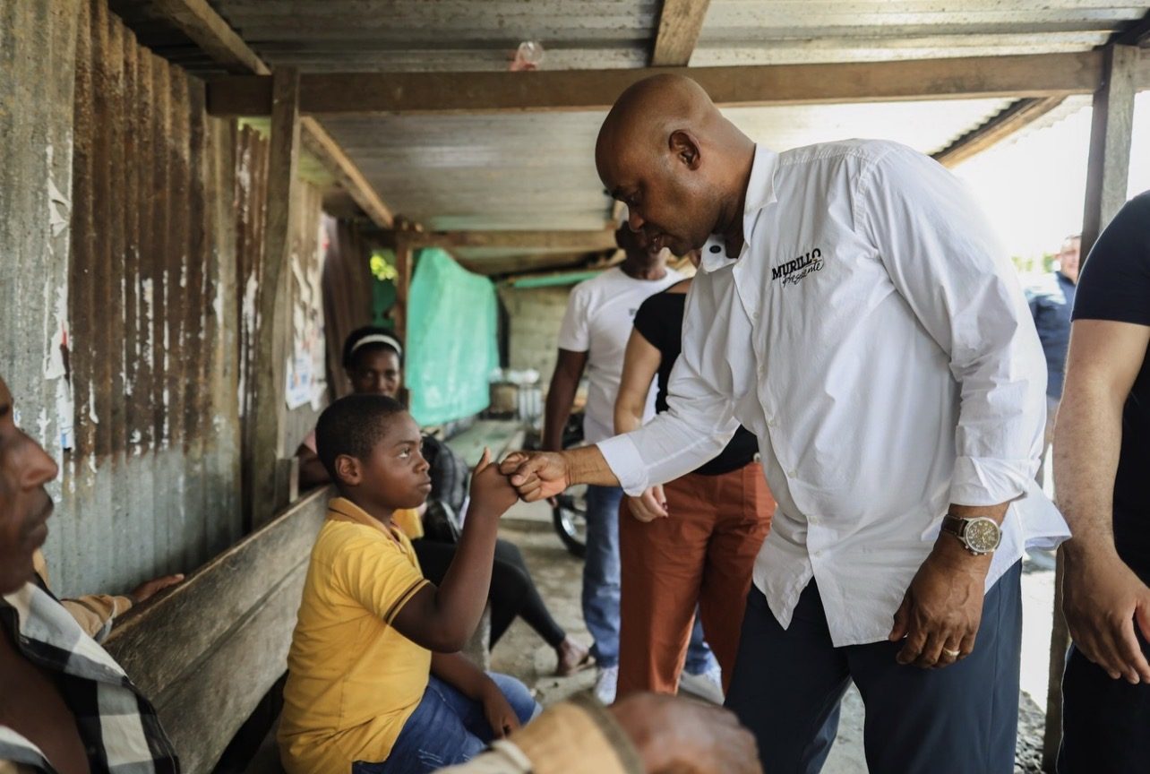 Luis Gilberto Murillo saludando a un niño en su comunidad